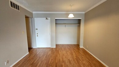 Unfurnished bedroom with wood finished floors, a closet, and crown molding