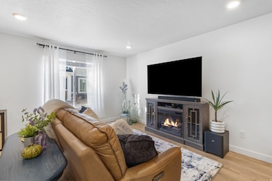 Open concept living area with light wood-style flooring, recessed lighting, and natural light