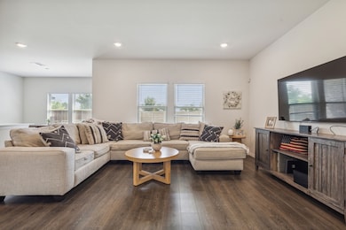 Living room with dark wood finished floors and recessed lighting