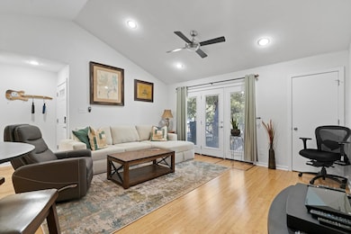 Living room featuring ceiling fan, vaulted ceilin
