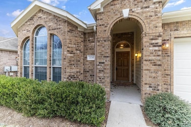 Doorway to property featuring brick siding and an attached garage