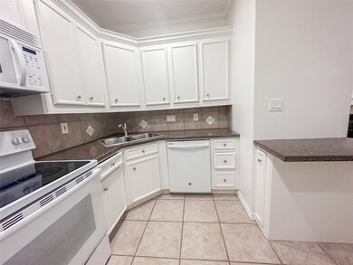 The kitchen seamlessly connects to the living room for an open and functional layout while featuring modern electric appliances- including a convenient dishwasher, ensuring efficiency and ease for everyday meal prep and cleanup.