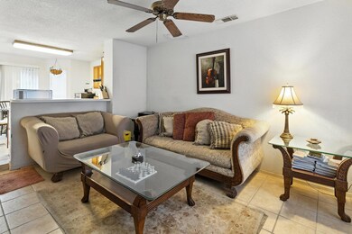Living room with ceiling fan, a textured ceiling,