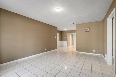 Empty room featuring a textured ceiling and light