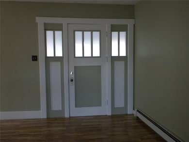 Foyer with a baseboard radiator and dark wood-style flooring