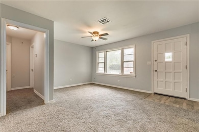 Carpeted foyer featuring baseboards and ceiling fan