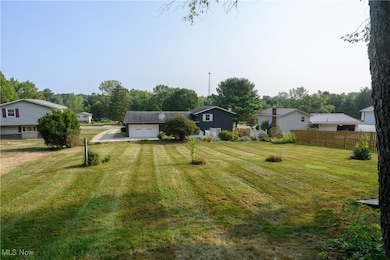 View of yard featuring driveway and a garage