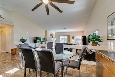 Dining room with ceiling fan, vaulted ceiling, and