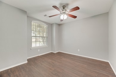 Unfurnished room with dark wood finished floors and a ceiling fan