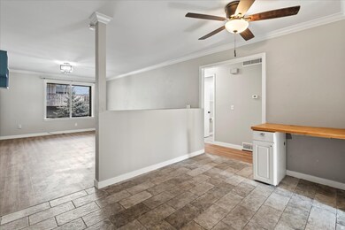 Unfurnished room featuring crown molding, an office area, and ceiling fan