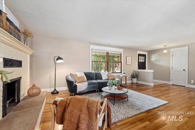 Living area featuring wood finished floors, a fireplace, and a textured ceiling