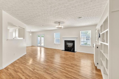 Spacious living room with fireplace, built-ins, and direct patio access.