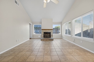The living room offers an open and airy feel with vaulted ceilings, large windows, and a brick fireplace that creates a warm and inviting home.
