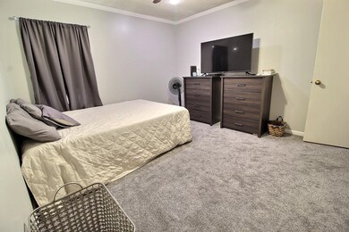 Bedroom with light carpet and crown molding