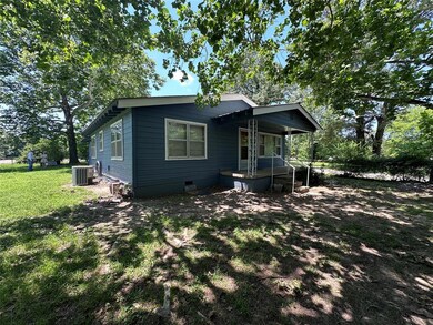 Rear view of property featuring central AC unit, covered porch, a yard, and crawl space