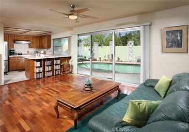The expansive family room with its designer lighted ceiling fan, rich wood flooring and easy access to the backyard is perfect for entertaining or family gatherings.