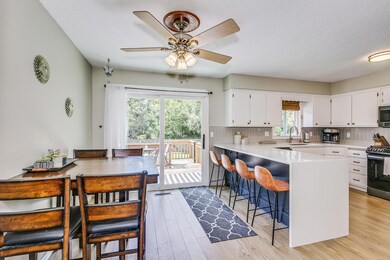 Kitchen and dining area lead onto deck overlooking pool and backyard.