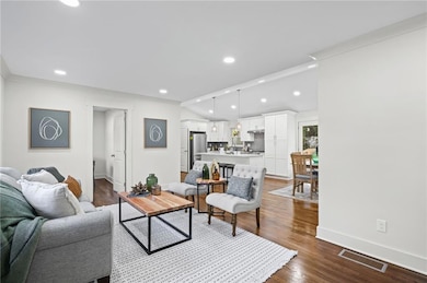 Living room with dark wood-style flooring, recessed lighting, and vaulted ceiling