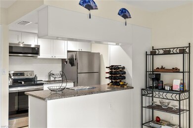 Kitchen featuring dark stone counters, white cabin