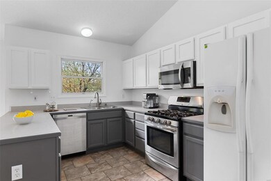 Stainless steel appliances include a 5-burner gas 