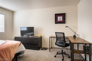 Bedroom down stairs with carpet flooring, a desk,