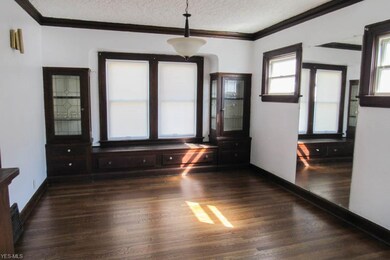 Formal dining room with built-in cabinets, crown molding and a window seat.