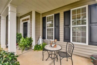 Pretty front porch overlooks streets with sidewalk