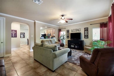 Living room featuring arched walkways, ceiling fa