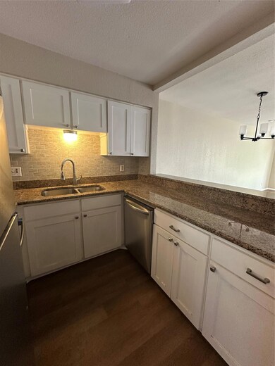 Kitchen featuring dishwasher, dark wood-style flo