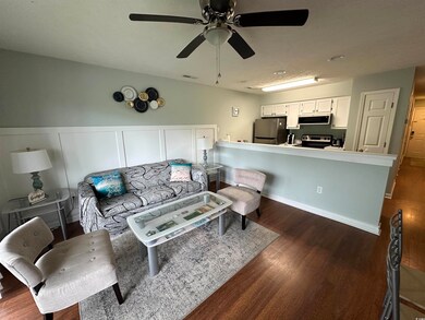 Living room featuring dark wood-style flooring and a ceiling fan