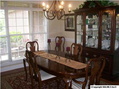 The formal dining room with hardwood floors, detailed crown molding, chair rail, and floor to ceiling windows for plenty of sun light. Every room in this home has plenty of sun light.