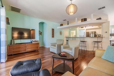 The spacious living room offers a welcoming gathering space and features triple-pocket sliding glass doors that lead to a screened-in patio.