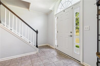 Entrance foyer featuring ornamental molding, stairs, and tile patterned flooring