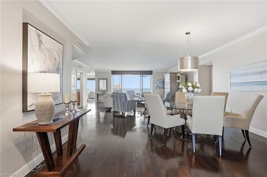 Dining room with crown molding and dark wood-type flooring