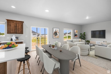 Dining space featuring recessed lighting, light wood-style floors, and a textured ceiling