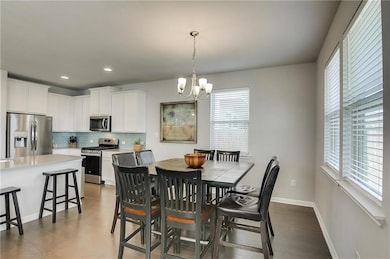 Dining area featuring a chandelier, dark wood-typ