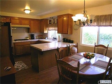 Updated kitchen with tile counters and oak cabinet