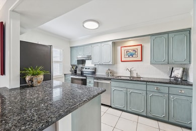 The kitchen is equipped with new stainless appliances, custom painted cabinetry and stylish tile backsplash.