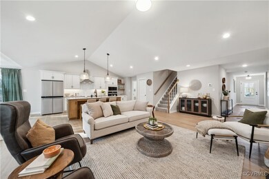 Living room featuring light wood finished floors, recessed lighting, stairway, baseboards, and lofted ceiling