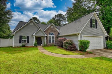 Traditional-style house featuring concrete driveway, roof with shingles, a garage, and a gate