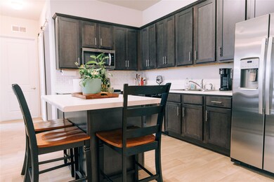 Kitchen featuring stainless steel appliances, tas
