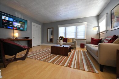 Living room with a textured ceiling and hardwood / wood-style flooring