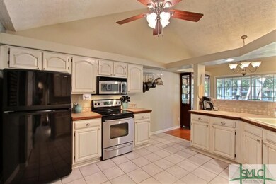 Open tiled kitchen with loads of cabinet space!  A
