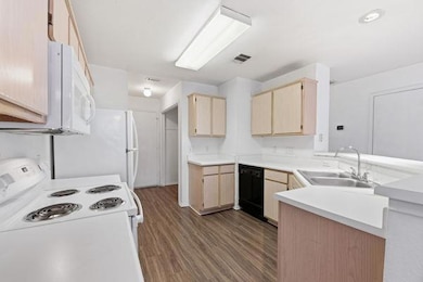 Kitchen featuring light brown cabinetry, white ap