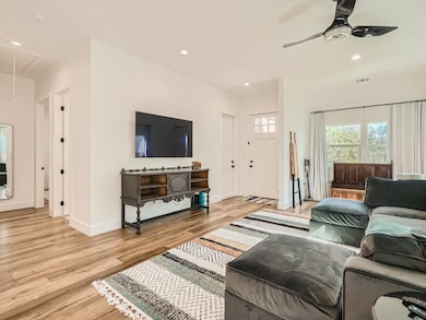 Living area with attic access, wood finished floo