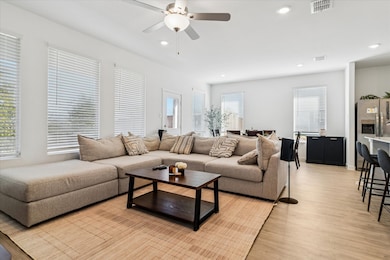 Living room featuring recessed lighting, light wood-type flooring, and a ceiling fan