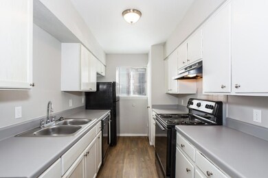 Kitchen with dark wood finished floors, a sink, bl