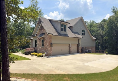 View of home's exterior featuring brick siding, a shingled roof, driveway, and an attached garage