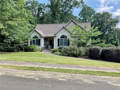View of front of house featuring a front lawn and a shingled roof