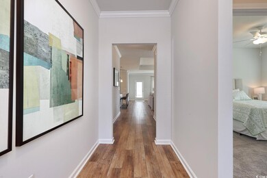 Hall featuring ornamental molding, baseboards, and
